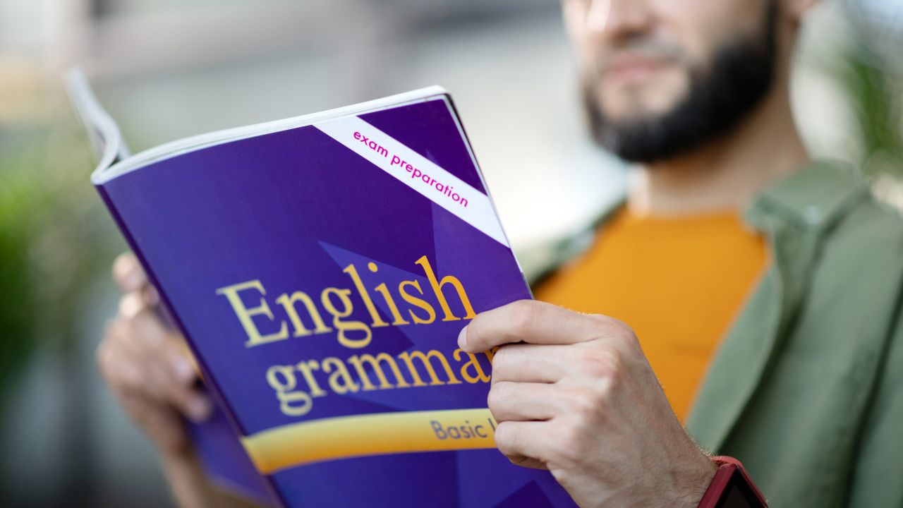 A person reading a book about English grammar